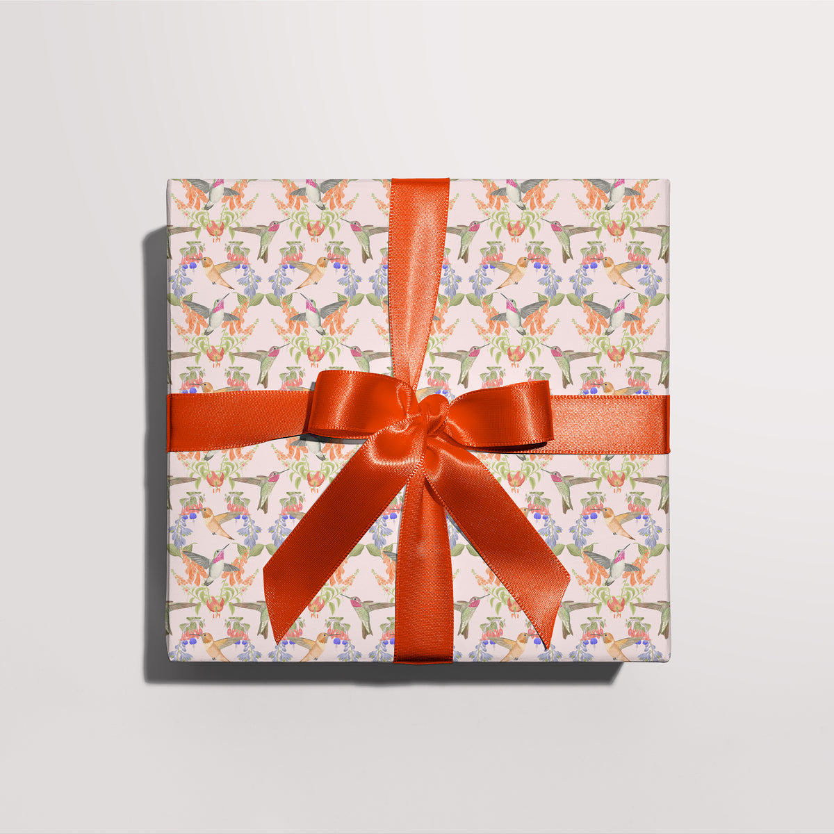 Gift wrapped in Hummingbird gift wrap with a red ribbon
